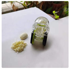 Roller garlic chopper with minced garlic and a garlic clove.